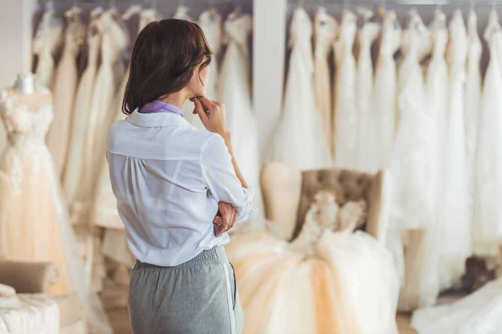 junge Frau wählt Kleid im Hochzeitssalon - Foto, Bild
