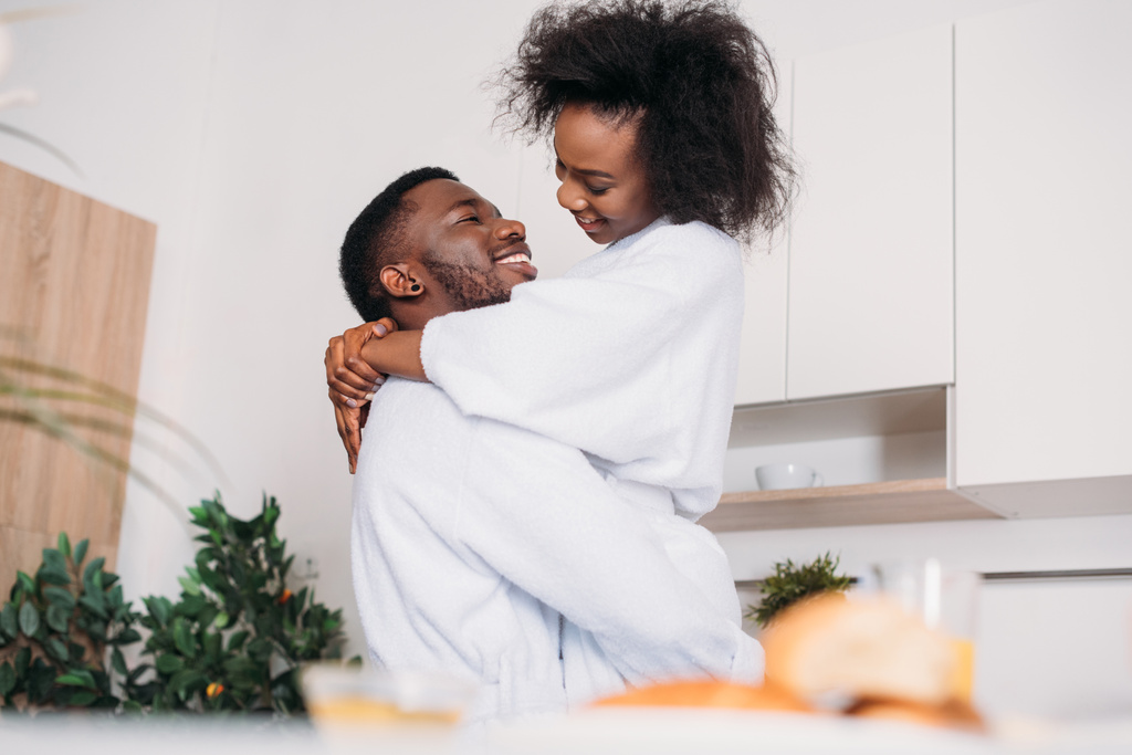 キッチンでアフリカ系アメリカ人のカップルの笑顔ローアングル ビュー - 写真・画像