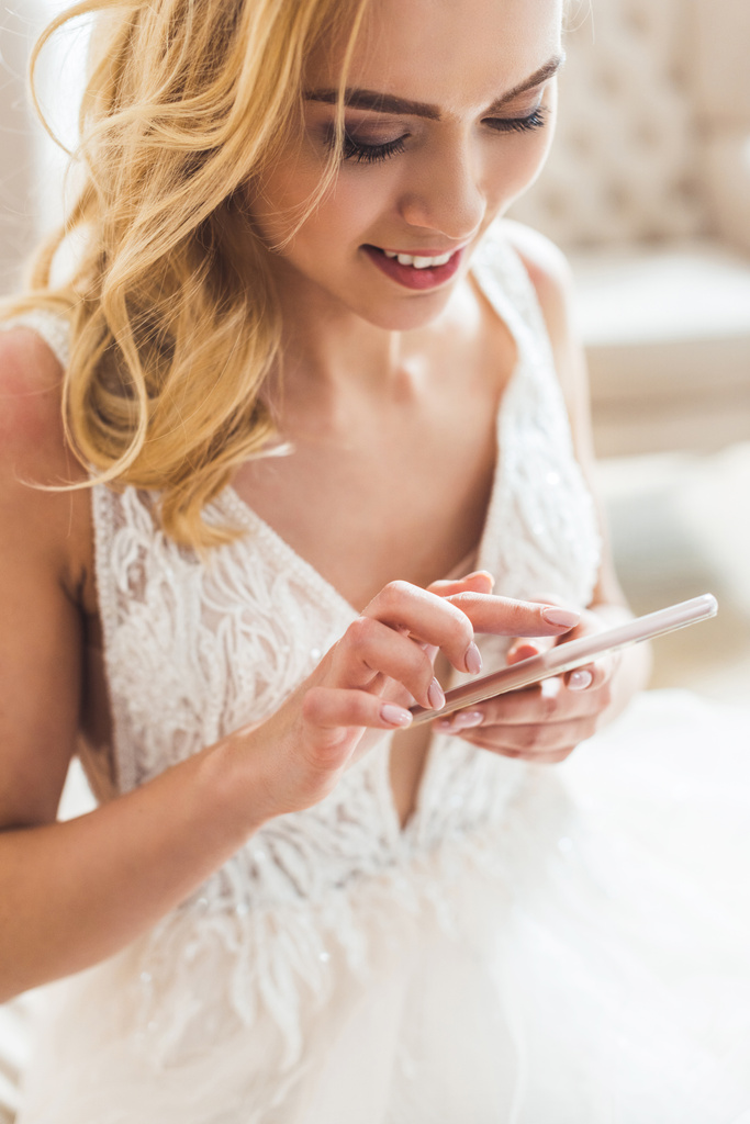 Молода наречена використовує смартфон у весільному салоні
 - Фото, зображення