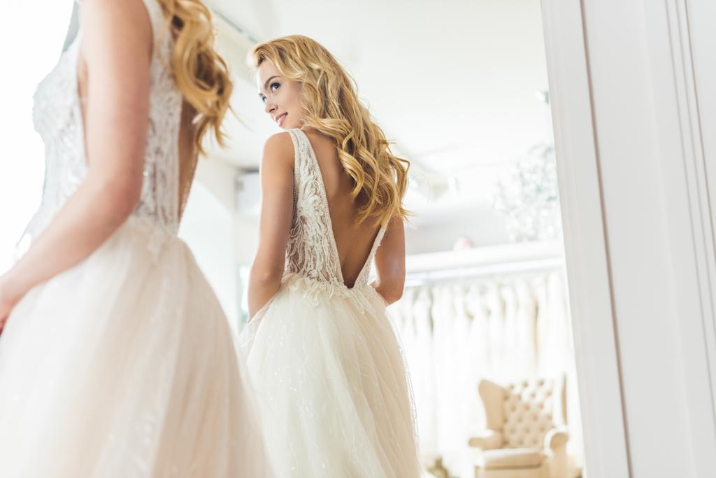 Elegante novia en vestido de encaje por espejo en el salón de bodas
 - Foto, imagen