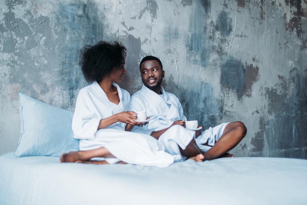 Афро-американських пара, сидячи в ліжко з чашок кави - Фото, зображення