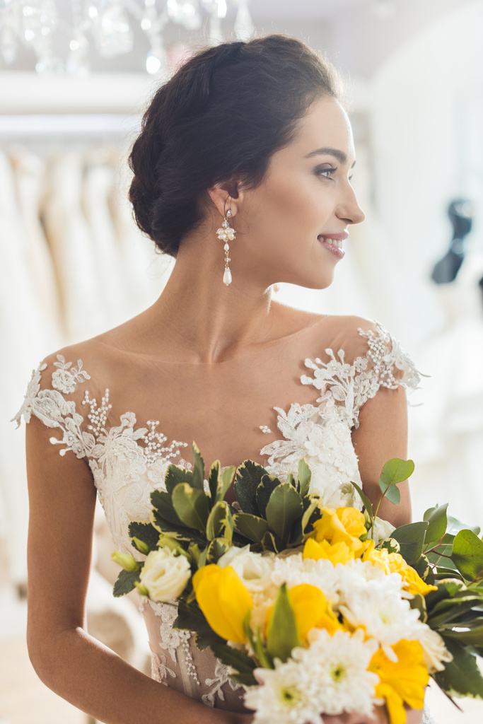 Hermosa novia con ramo floral en atelier de boda
 - Foto, imagen