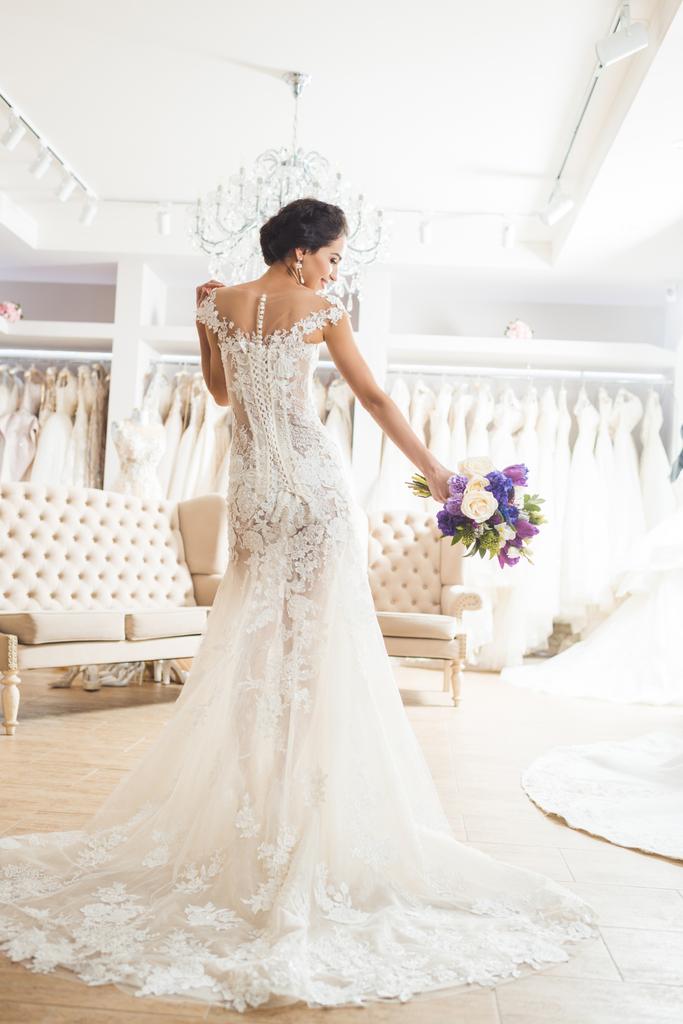 Όμορφη νύφη με floral ανθοδέσμη στο γάμο μόδας κατάστημα - Φωτογραφία, εικόνα