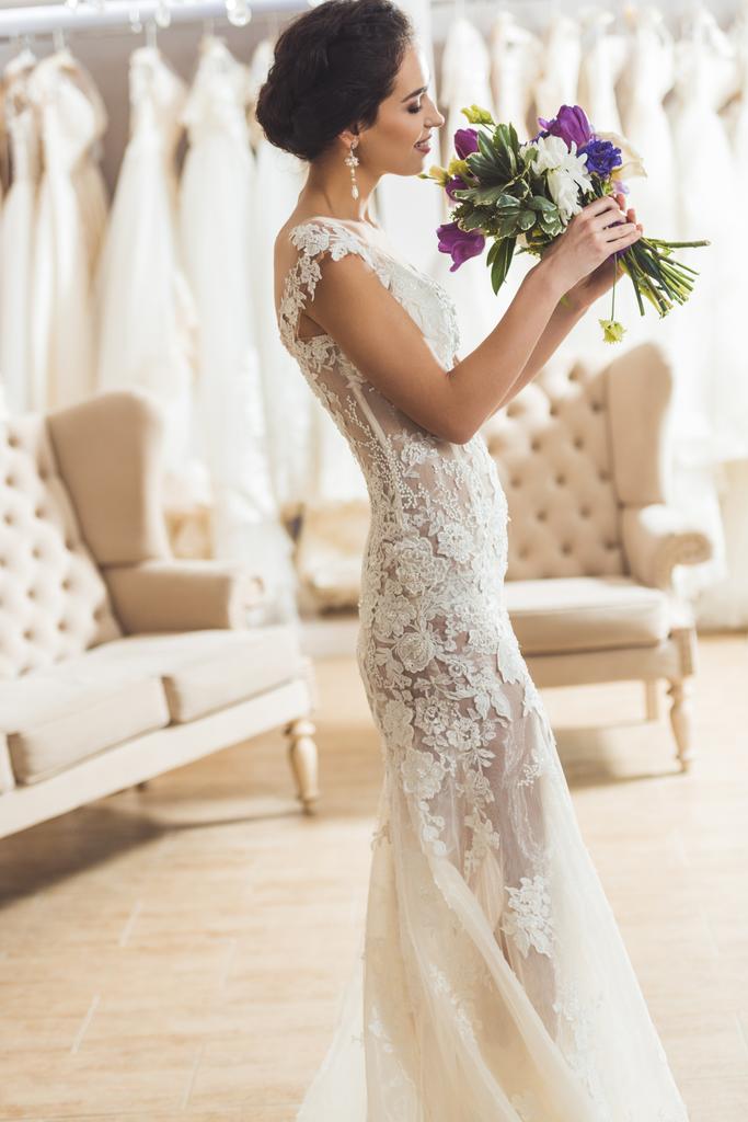 Mooie bruid met bloemen boeket in huwelijk salon - Foto, afbeelding