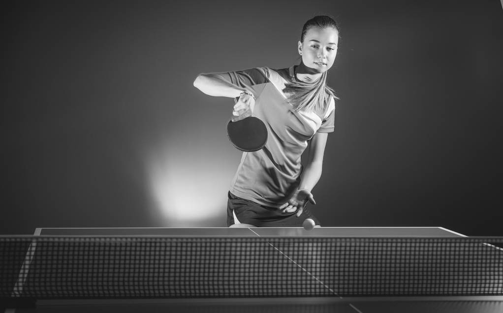 Porträt einer jungen Frau beim Tennisspielen auf schwarzem Hintergrund mit  - Foto, Bild