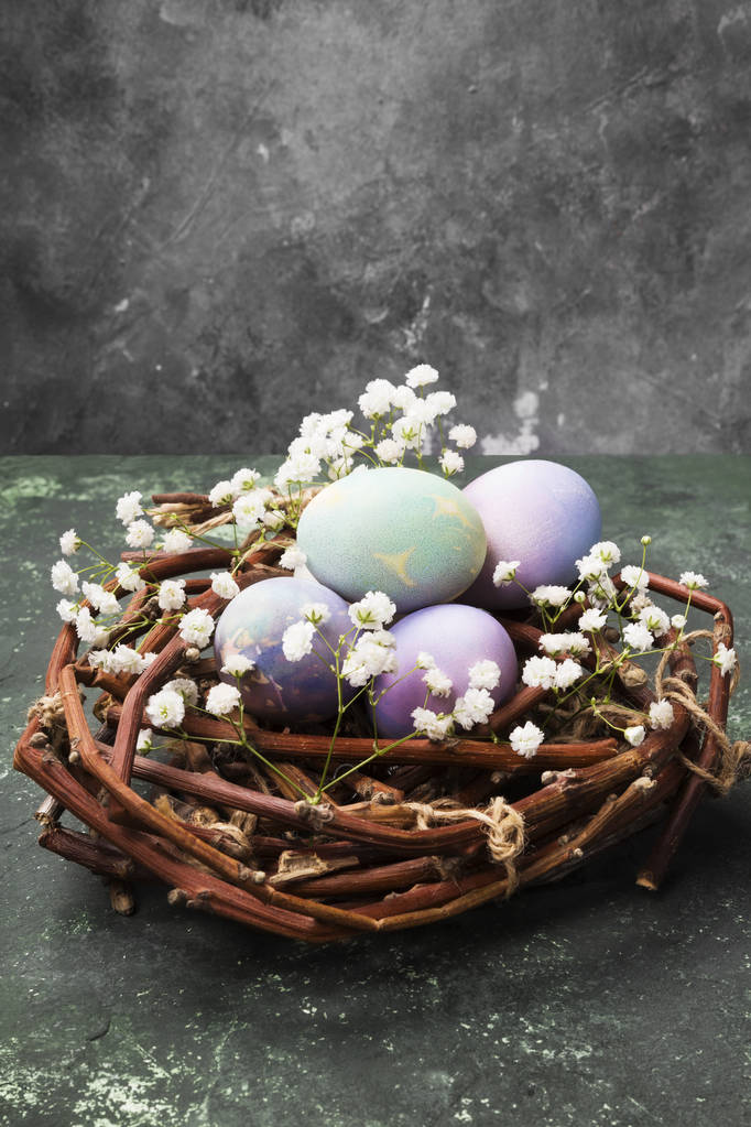 Bunte Eier für Ostern im Nest mit Blumen auf grünem Rücken - Foto, Bild
