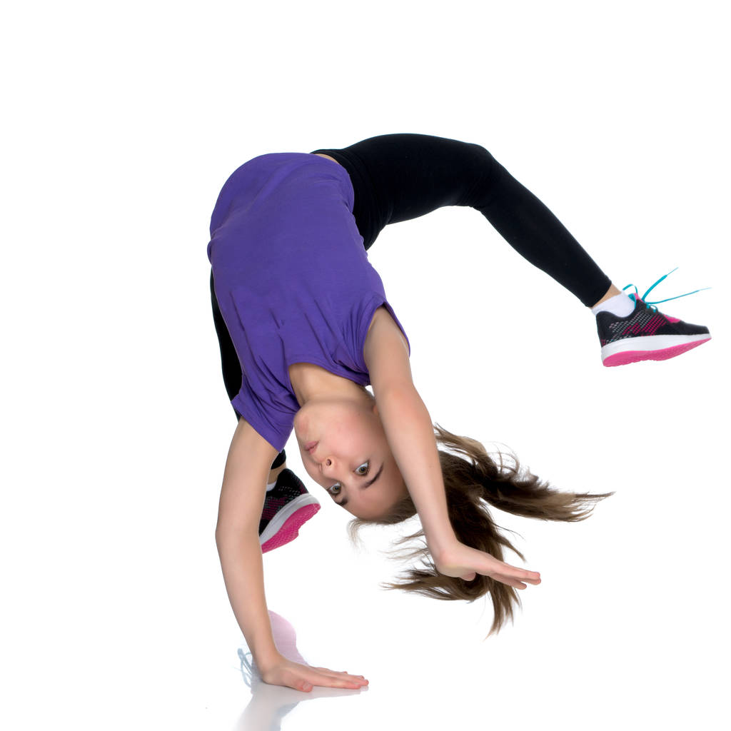 La gimnasta realiza un elemento acrobático en el suelo. - Foto, imagen