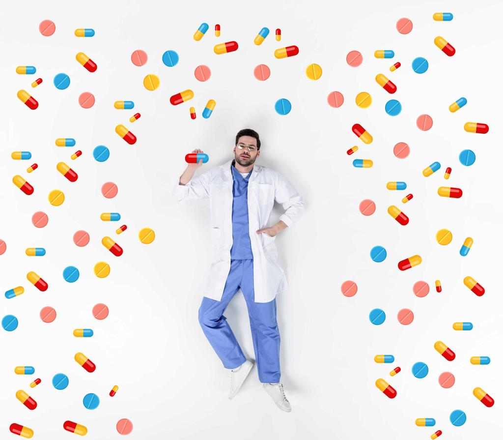collage creativo de guapo joven médico acostado en blanco rodeado de varias píldoras
 - Foto, imagen