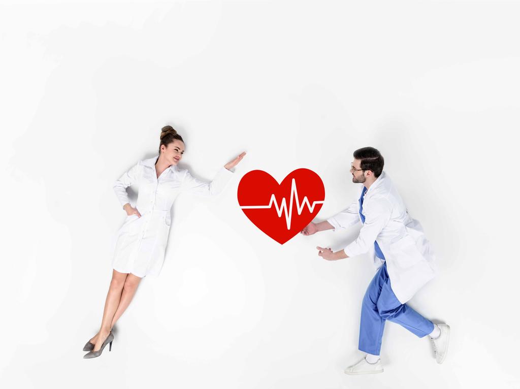 творчий колаж лікарів чоловічої та жіночої статі зі знаком серцебиття на білому
 - Фото, зображення