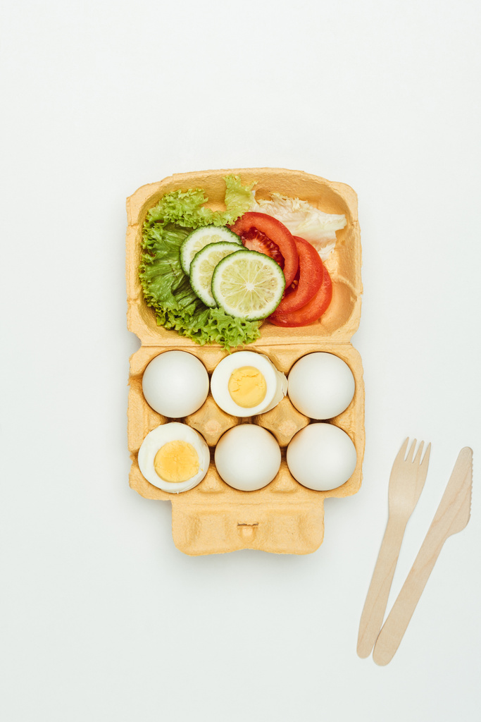 Κάτοψη των λαχανικών και αυγά στον δίσκο αυγό που απομονώνονται σε λευκό - Φωτογραφία, εικόνα