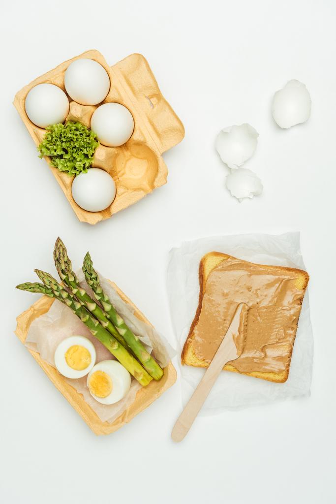 top view of bread with peanut butter and eggs on tray isolated on white - Photo, Image