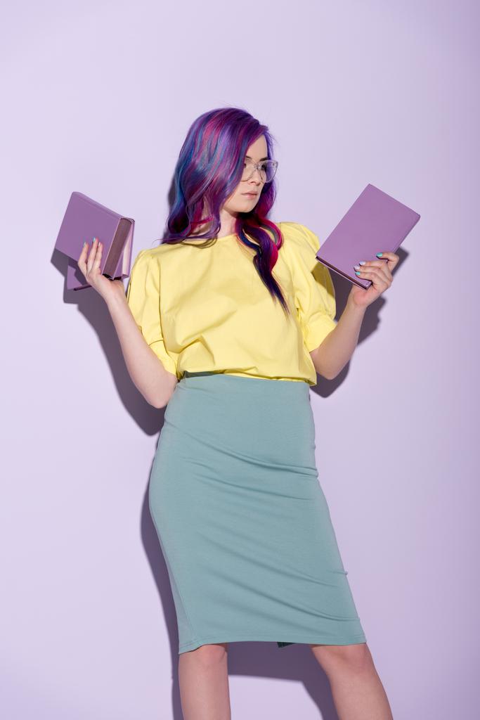 カラフルな髪のピンクの本を保持している魅力的な若い女性 - 写真・画像