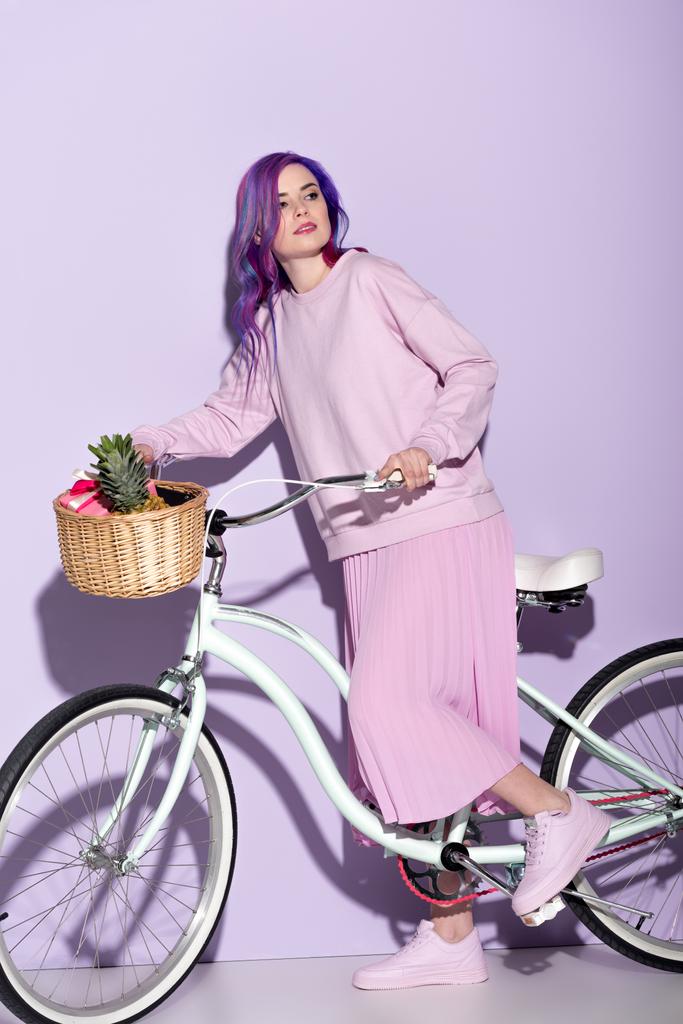 パイナップルとバナナ バスケット自転車にピンクの服で魅力的な女性 - 写真・画像