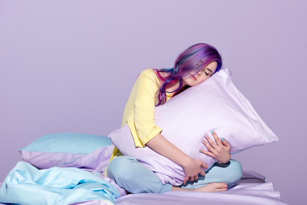 somnolent jeune femme assise dans le lit et embrassant oreiller
 - Photo, image