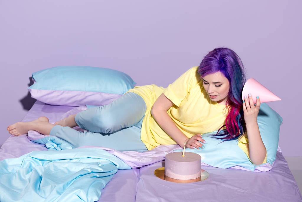 piękna młoda kobieta z urodziny tort i party hat w łóżku - Zdjęcie, obraz