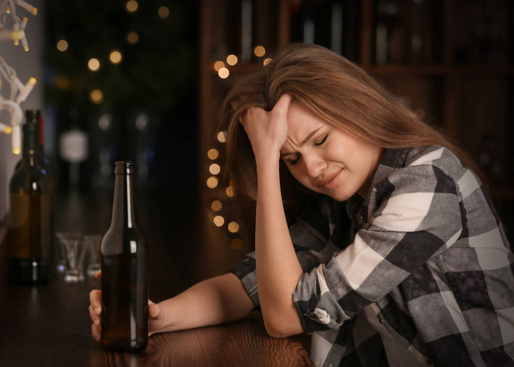 飲み物のボトルを持つ悲しい女のバー。アルコール依存症の問題 - 写真・画像