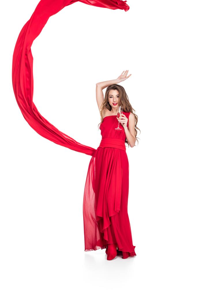 Glamouröses Mädchen in Rot mit Chiffonschleier, das Champagnerglas hält, isoliert auf Weiß - Foto, Bild