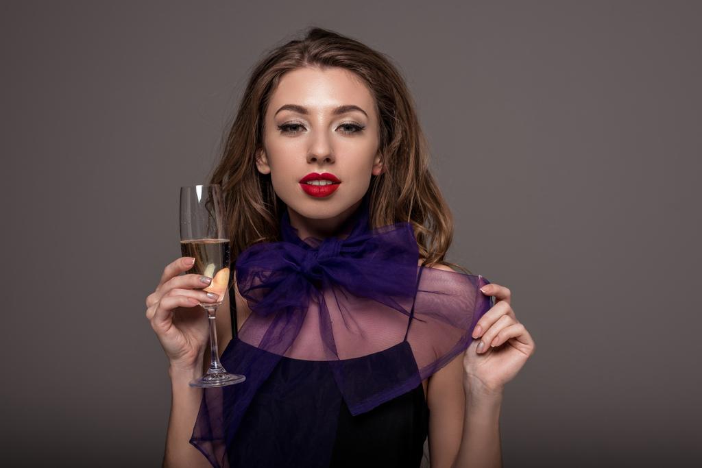 attractive girl posing with champagne glass, isolated on grey - Photo, Image