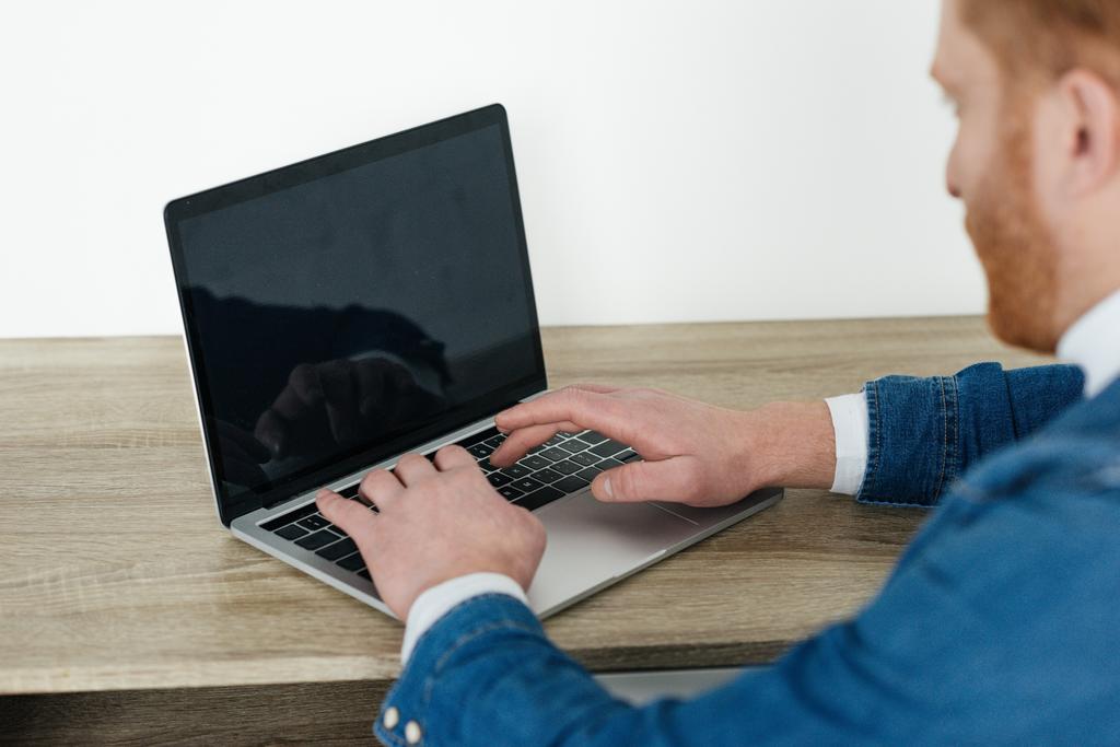 Homem ruivo digitando no teclado do laptop
 - Foto, Imagem