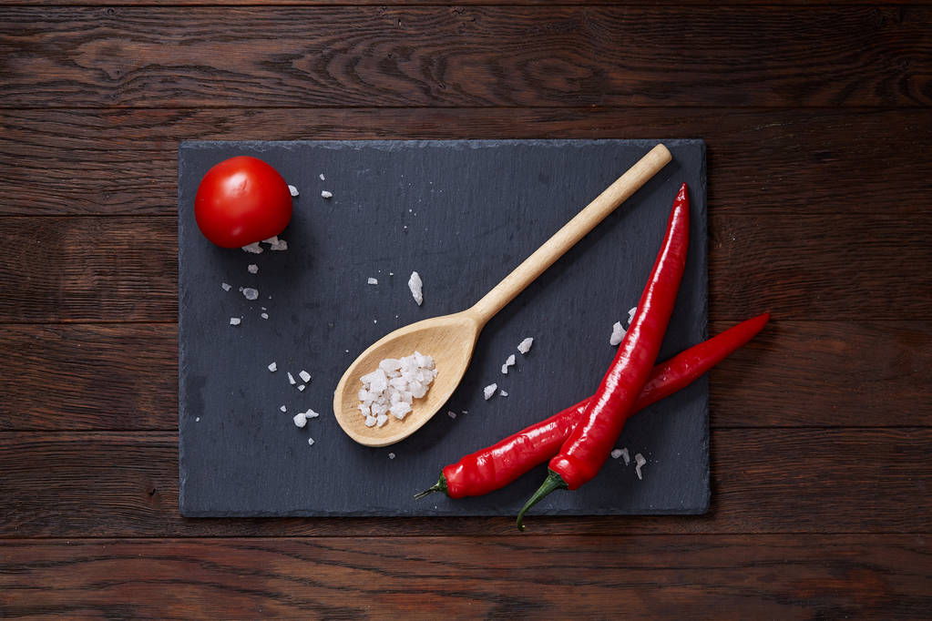 Vegetarian still life with fresh grape tomatoes, pepper and salt in wooden spoon on wooden background, selective focus - Photo, Image