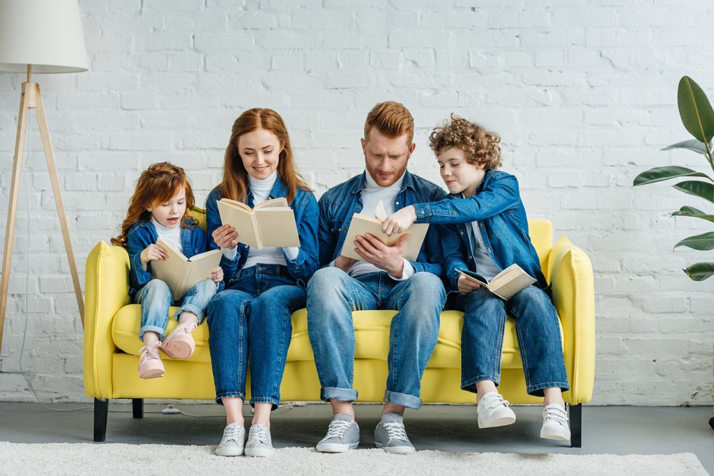 Padres e hijos sentados en un sofá y leyendo libros
 - Foto, Imagen