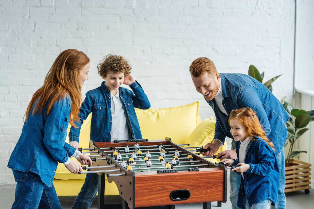 Família feliz se divertindo enquanto joga pebolim
  - Foto, Imagem