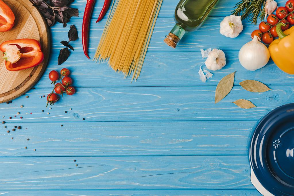 вид зверху інгредієнтів для приготування макаронних виробів на синьому столі
 - Фото, зображення