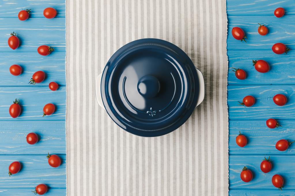 vista superior de tomates cereja com panela na mesa azul
 - Foto, Imagem