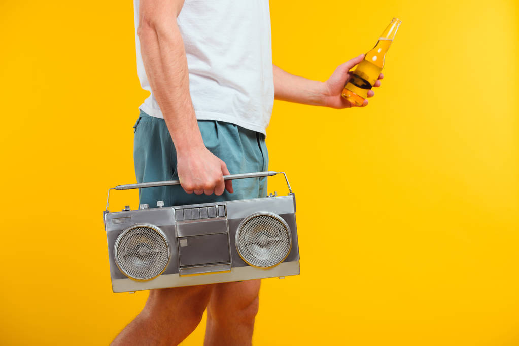 cropped shot of man in shorts holding tape recorder and glass bottle of summer drink - Photo, Image