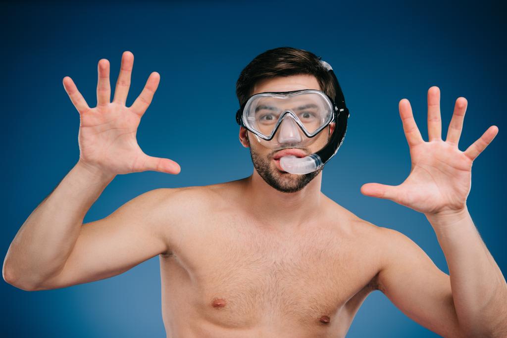 jovem alegre em snorkel e máscara de mergulho gesticulando com as mãos e olhando para a câmera em azul
 - Foto, Imagem