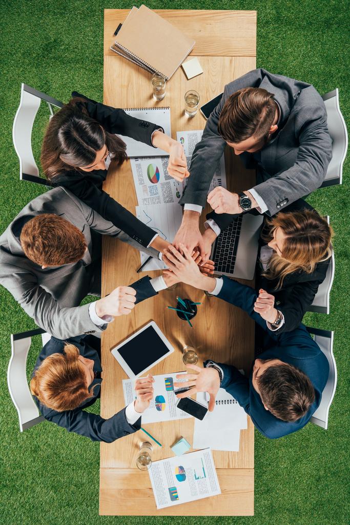 Верхний взгляд на бизнес-партнеров за столом в офисе, деловые круги
 - Фото, изображение