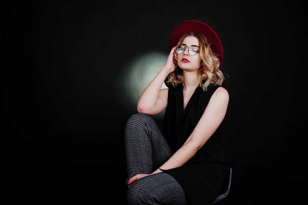 Studio portrait of blonde girl in black wear, red hat and glasse - Photo, Image