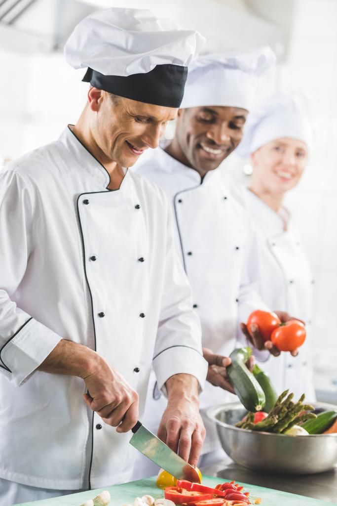 usmívající se multikulturní kuchaři vaření v kuchyni restaurace - Fotografie, Obrázek
