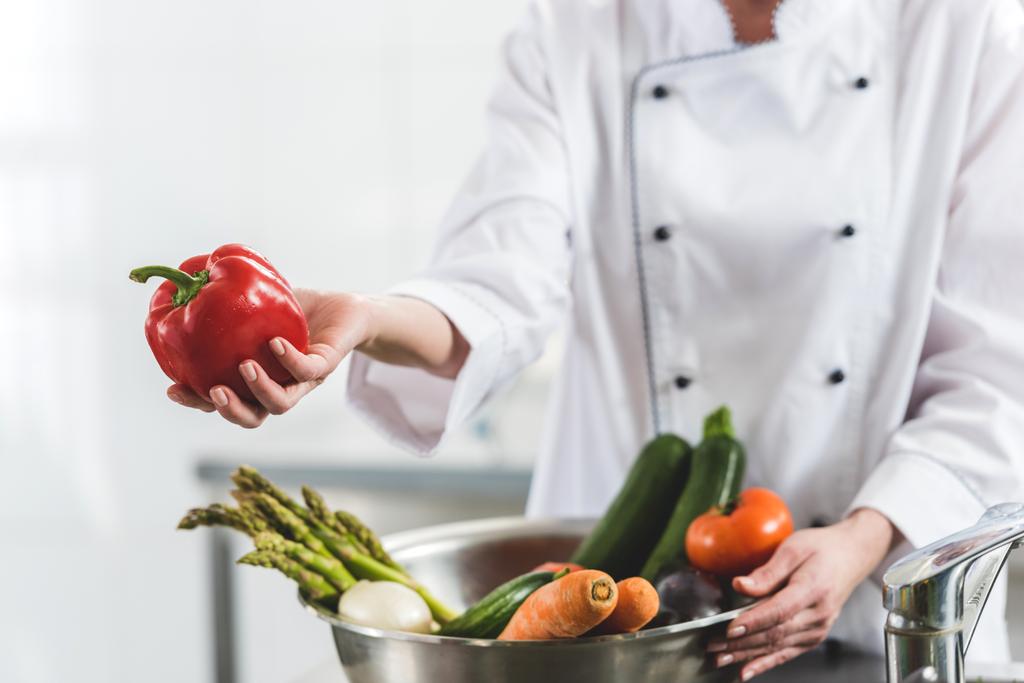 immagine ritagliata di chef dando peperone rosso a qualcuno in cucina ristorante
 - Foto, immagini