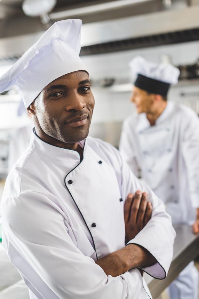 красивый африканский американский шеф-повар смотрит в камеру со скрещенными руками
 - Фото, изображение