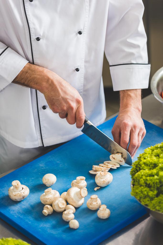 imagen recortada del chef cortando setas en la cocina del restaurante
 - Foto, Imagen