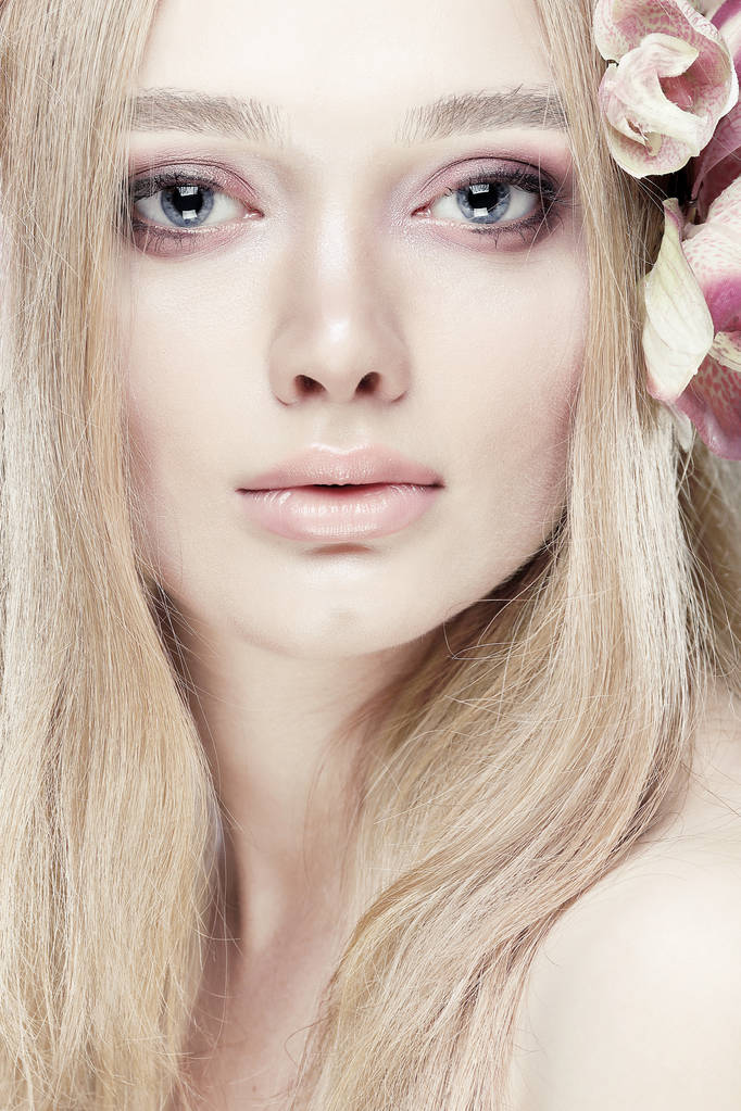 Piękna dziewczyna, na białym tle na światło - fioletowe tło z varicoloured kwiaty we włosy, emocje, kosmetyki - Zdjęcie, obraz