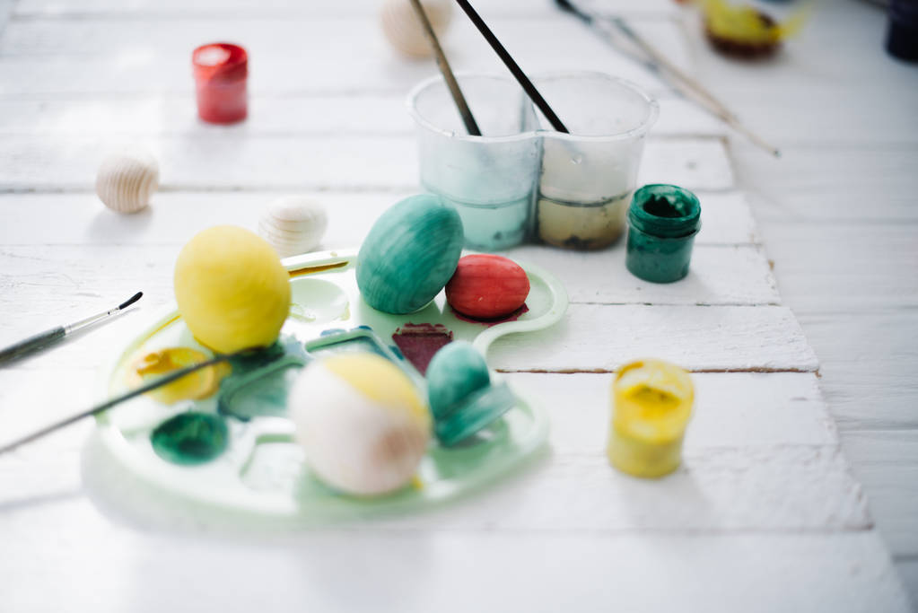 Le processus de peinture des œufs de Pâques nature morte sur un fond en bois blanc
 - Photo, image