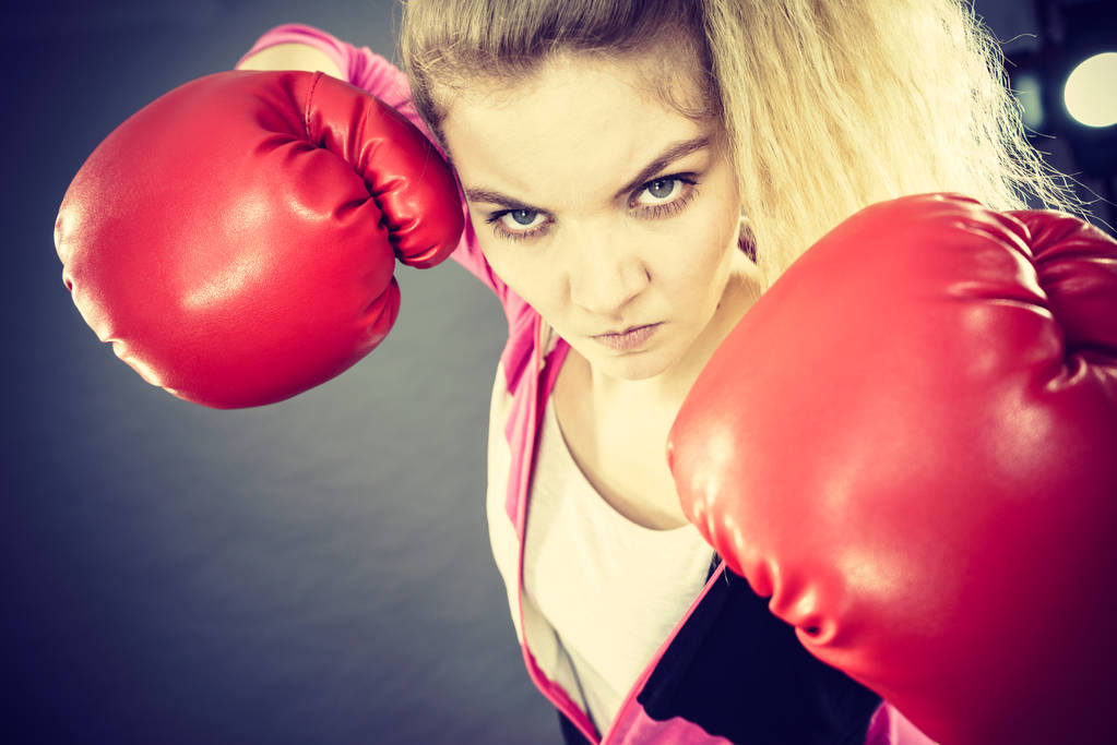 Mulher irritada vestindo luvas de boxe
 - Foto, Imagem