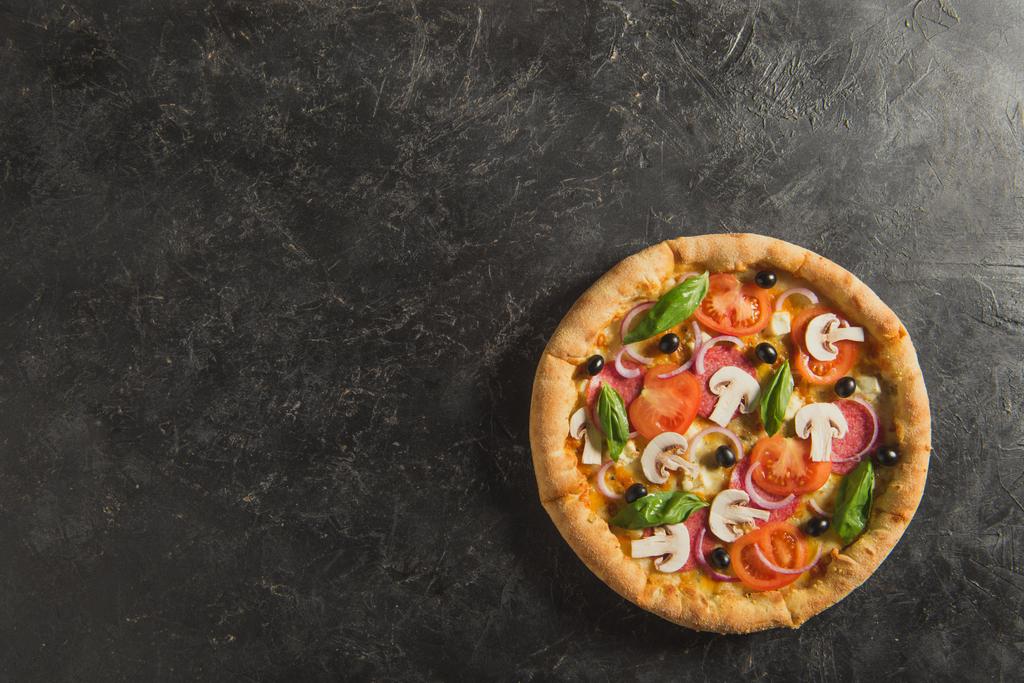 vista superior de la pizza italiana cocida en la mesa oscura
 - Foto, imagen