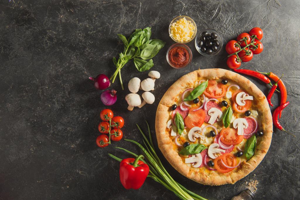 flache Lage mit italienischer Pizza und frischen Zutaten auf dunkler Oberfläche - Foto, Bild