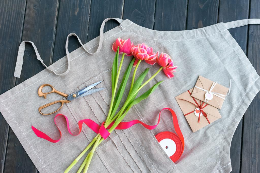 pohled shora na krásné tulipány s obálky, stuha a nůžky na odbavovací ploše - Fotografie, Obrázek