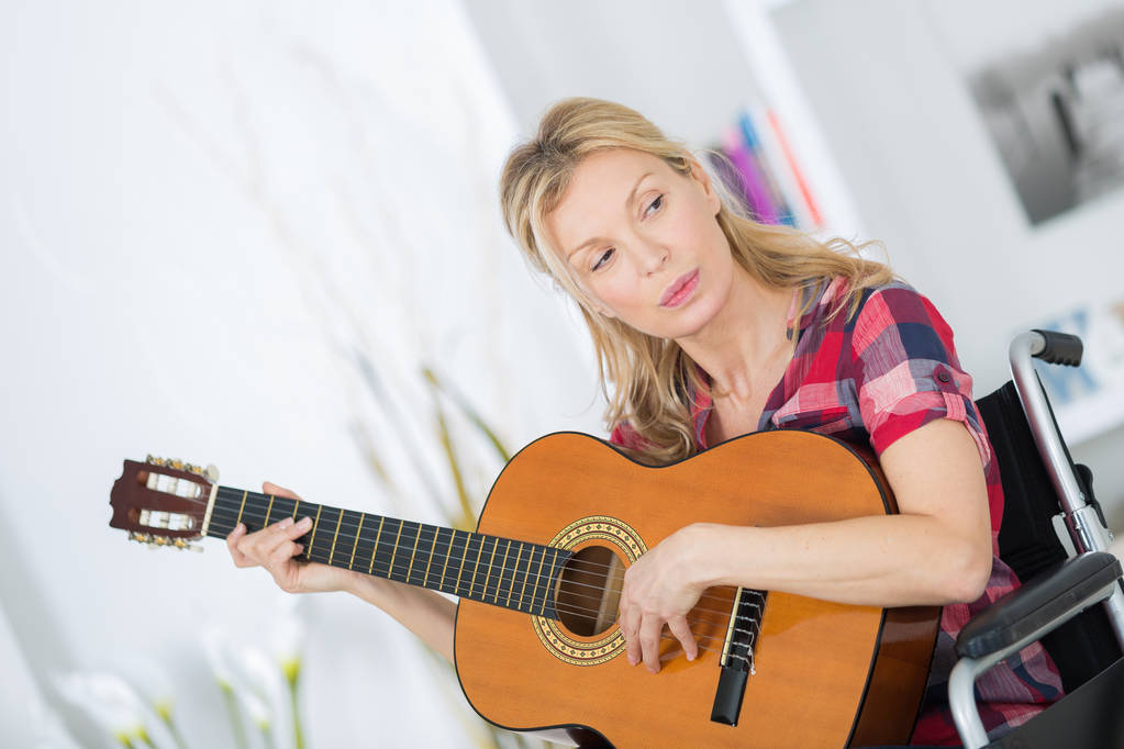 Lady nő zenész a kerekesszék gitározni otthon - Fotó, kép