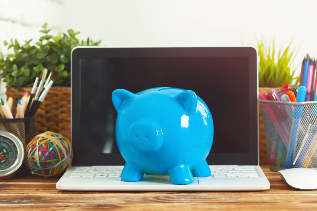 Caixa de dinheiro porquinho com laptop na mesa de madeira
 - Foto, Imagem