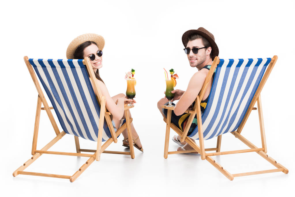 pareja sonriente relajarse en sillas de playa con cócteles, aislado en blanco
 - Foto, imagen