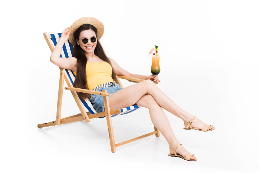 όμορφο κορίτσι σε γυαλιά ηλίου που ακουμπά στην παραλία καρέκλα με κοκτέιλ, απομονώνονται σε λευκό - Φωτογραφία, εικόνα