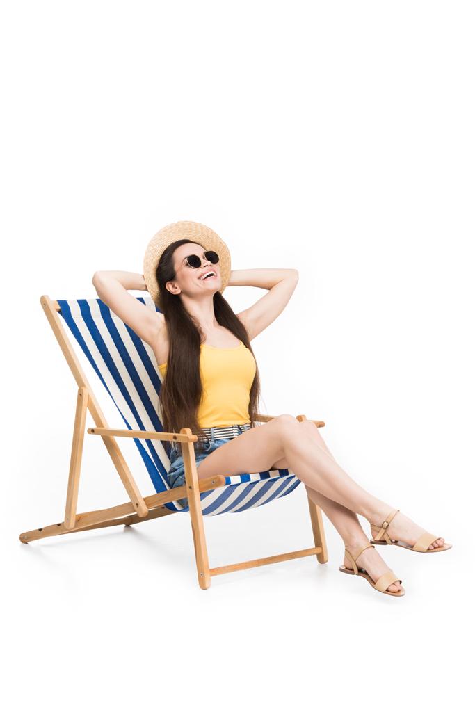 ευτυχισμένος νεαρή γυναίκα που ακουμπά στην παραλία καρέκλα, απομονώνονται σε λευκό - Φωτογραφία, εικόνα