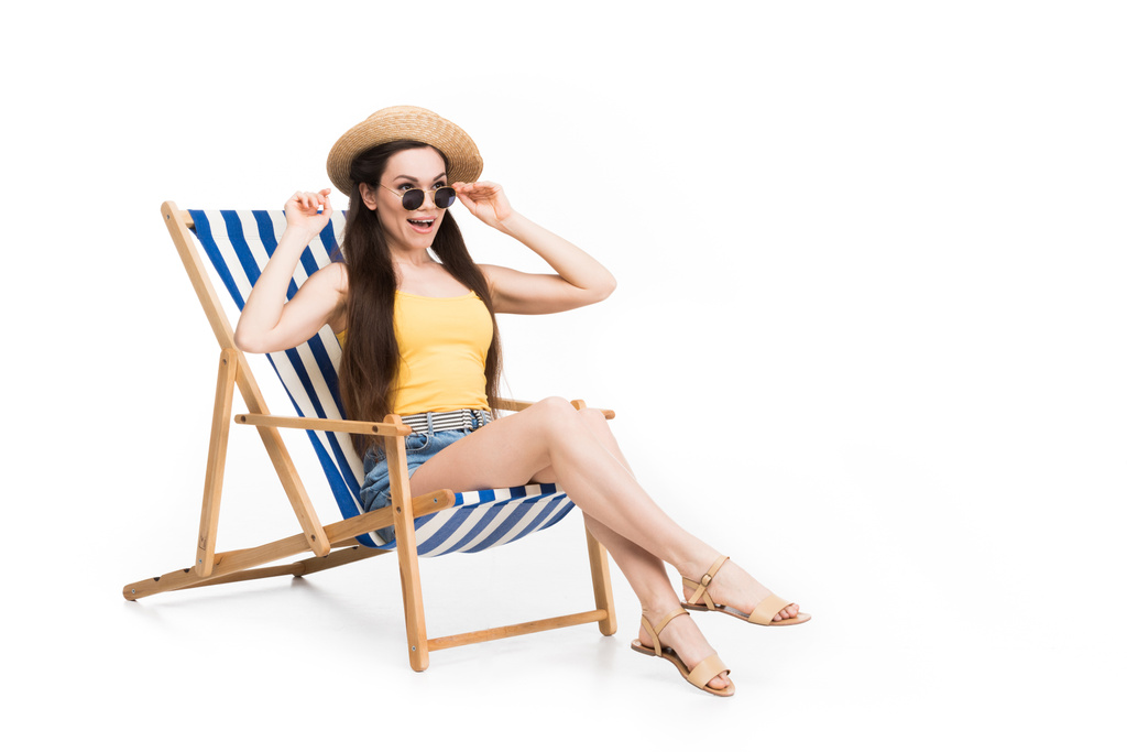schöne aufgeregte Frau entspannt sich im Strandkorb, isoliert auf weiß - Foto, Bild