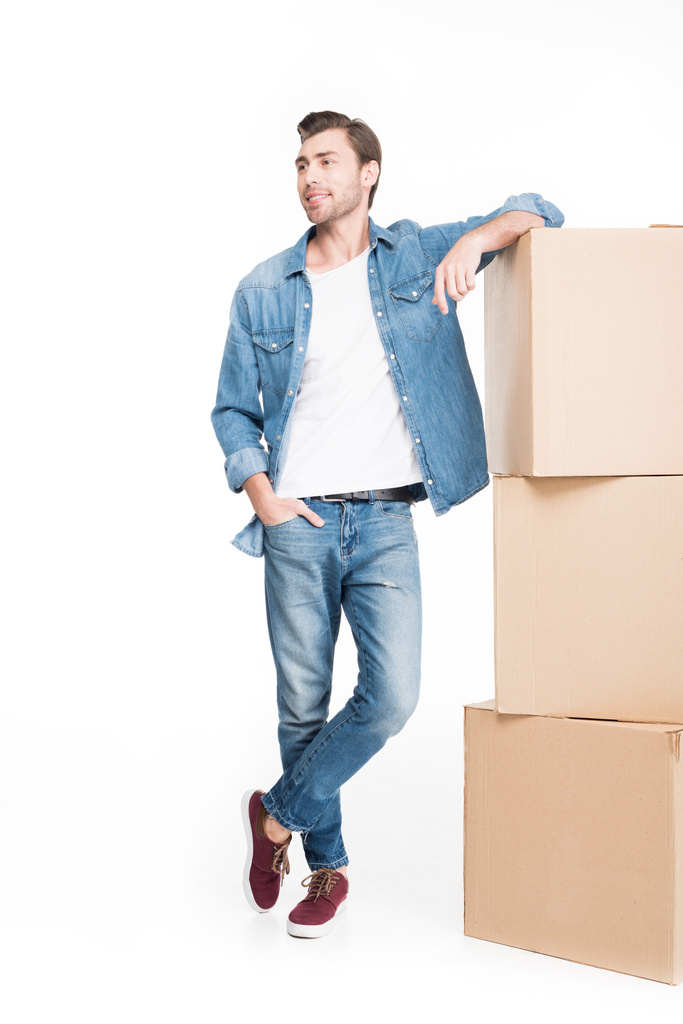 щасливий молодий чоловік рухається з картонними коробками, ізольований на білому
 - Фото, зображення