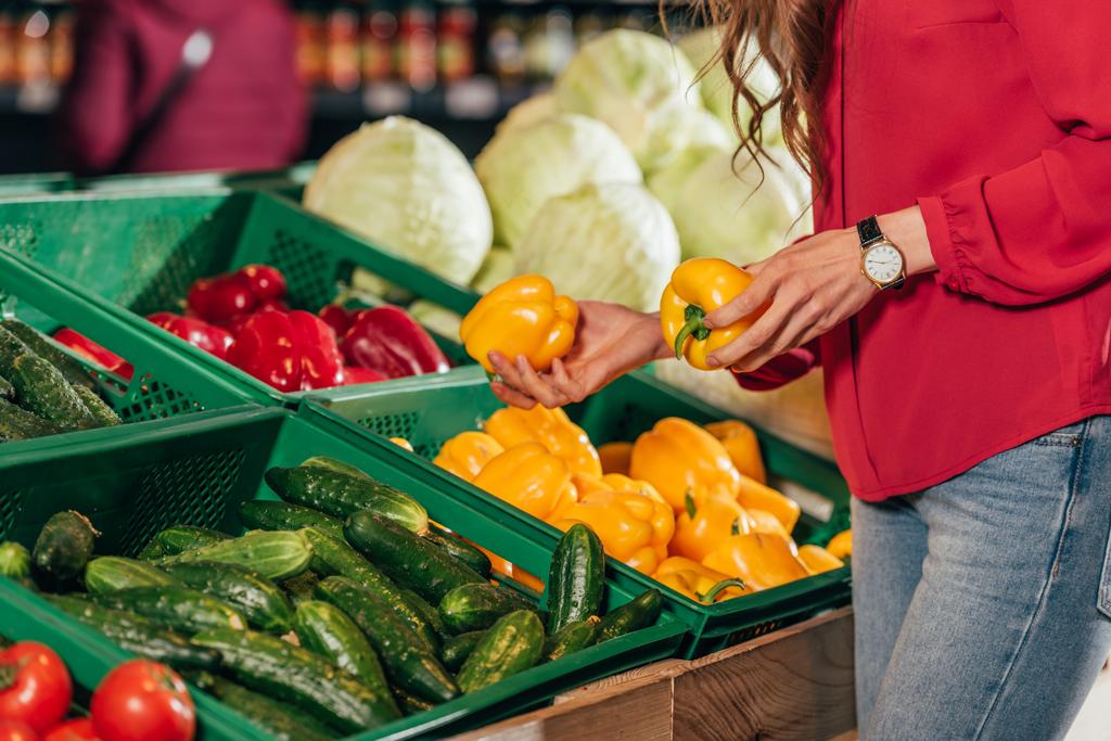 Teilansicht von Shoppern, die frische rohe Paprika im Supermarkt auswählen - Foto, Bild